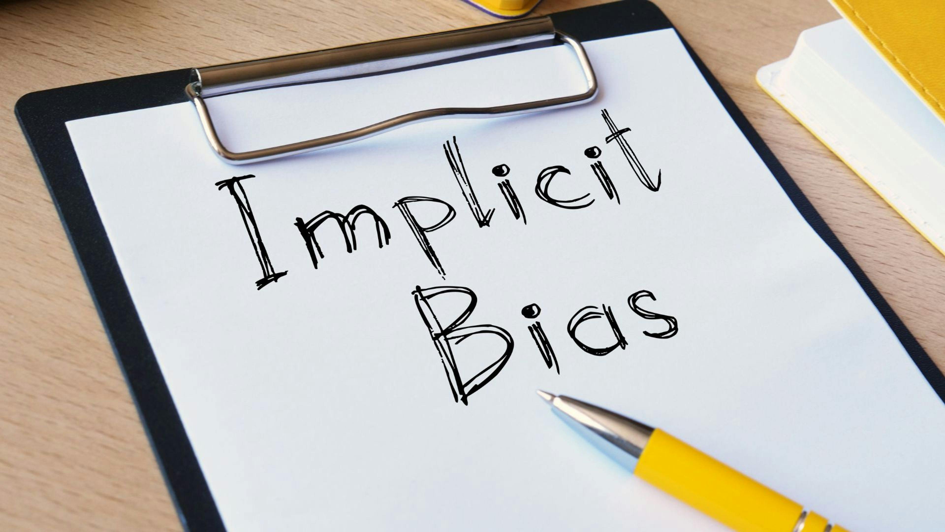 Image of words on a clipboard that read "Implicit Bias"