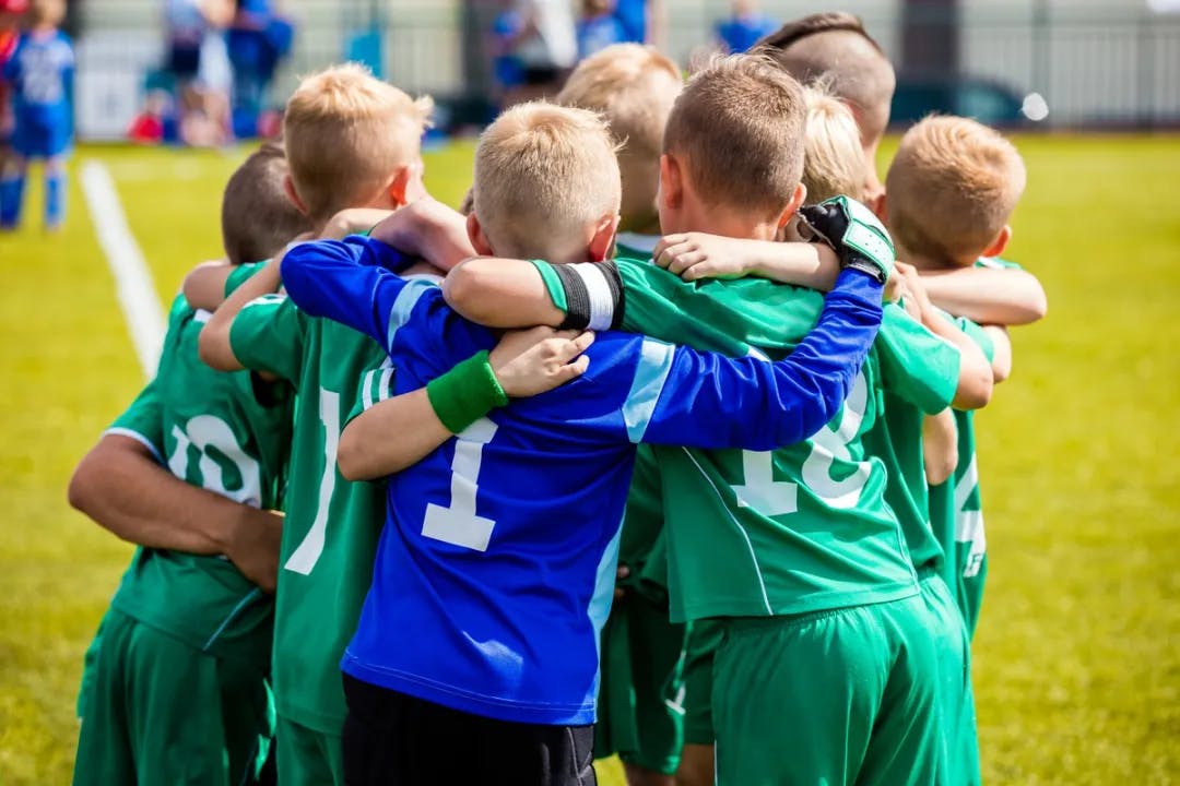 A team of kids in a group huddle