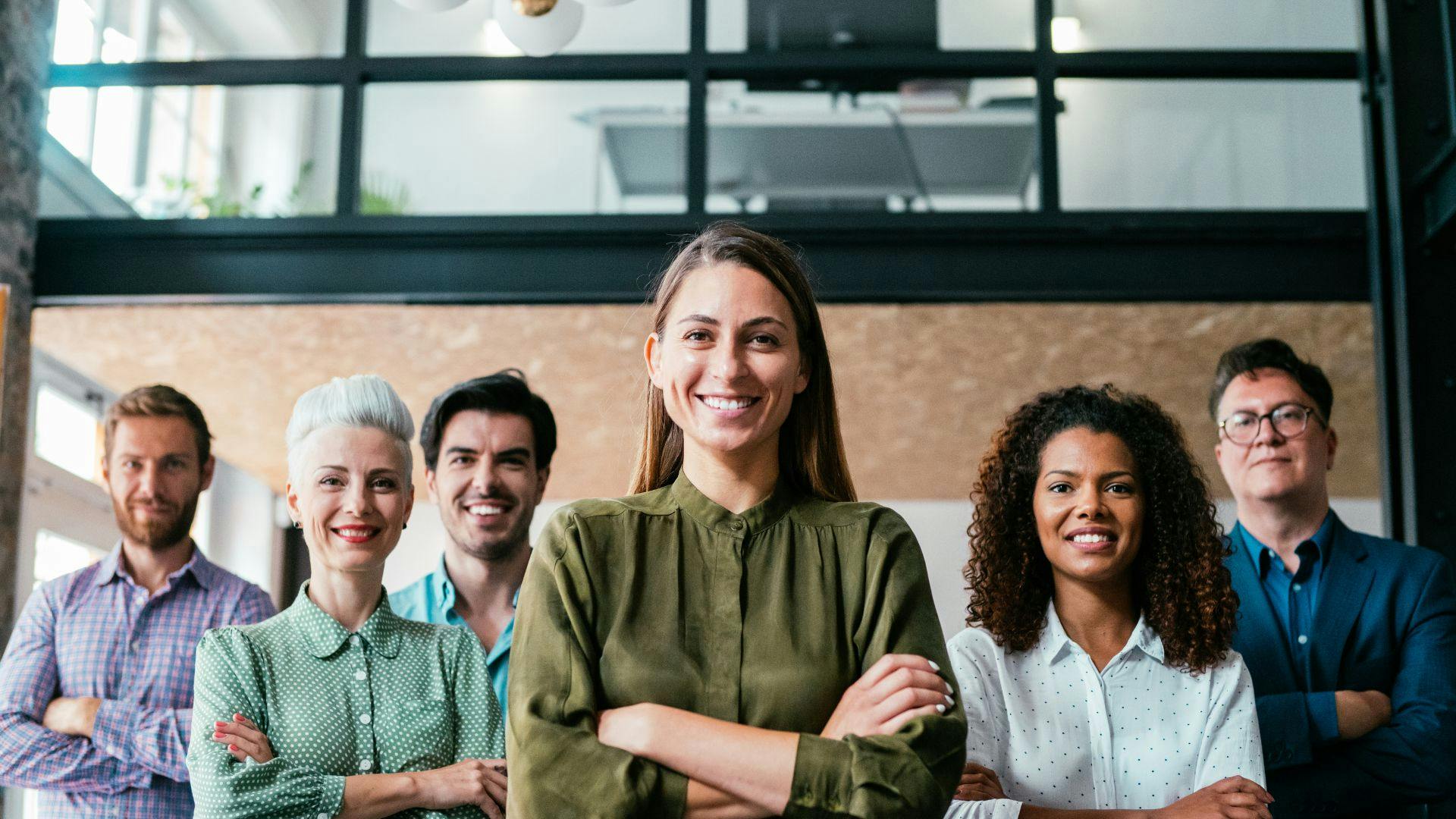 Group of happy employees looking into the camera smiling in an office setting. 