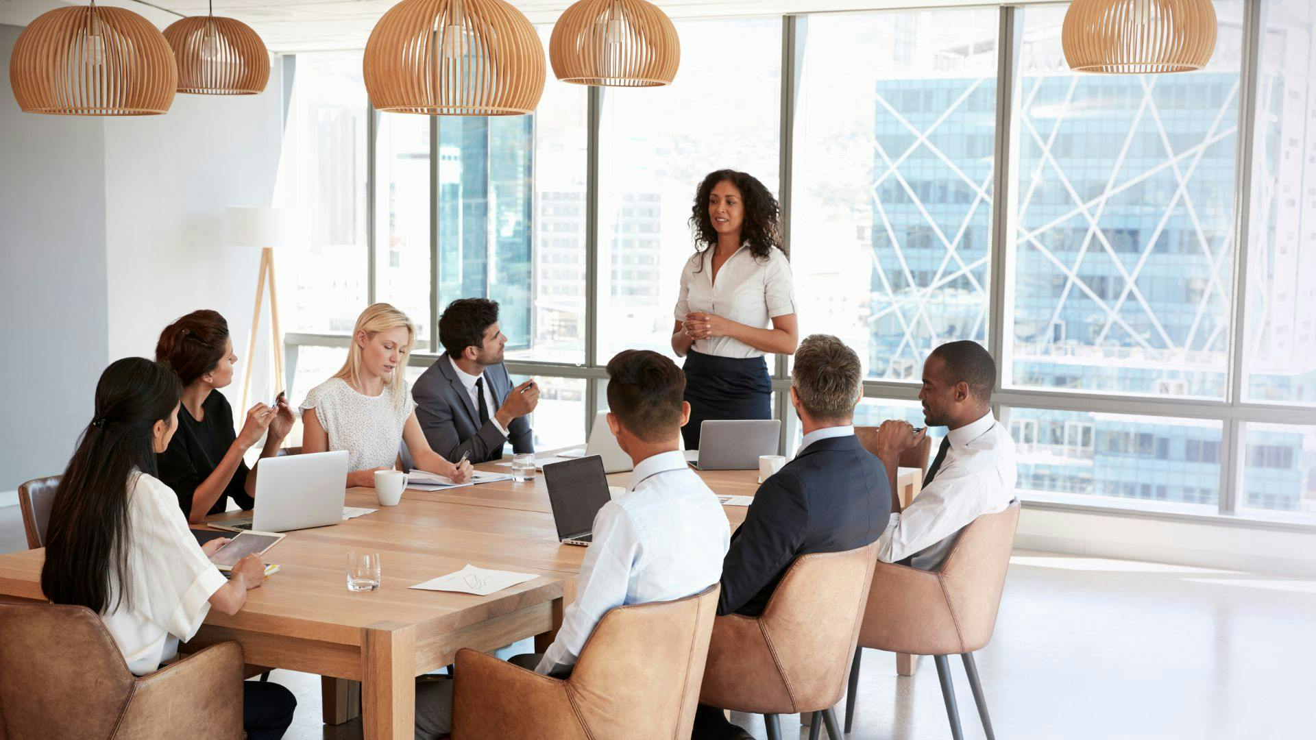 A woman presenting to a group of people in a conference room.