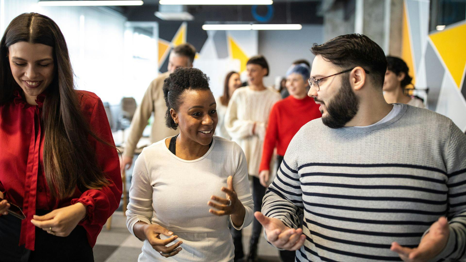 A group of professionals having a discussion in a modern office setting.