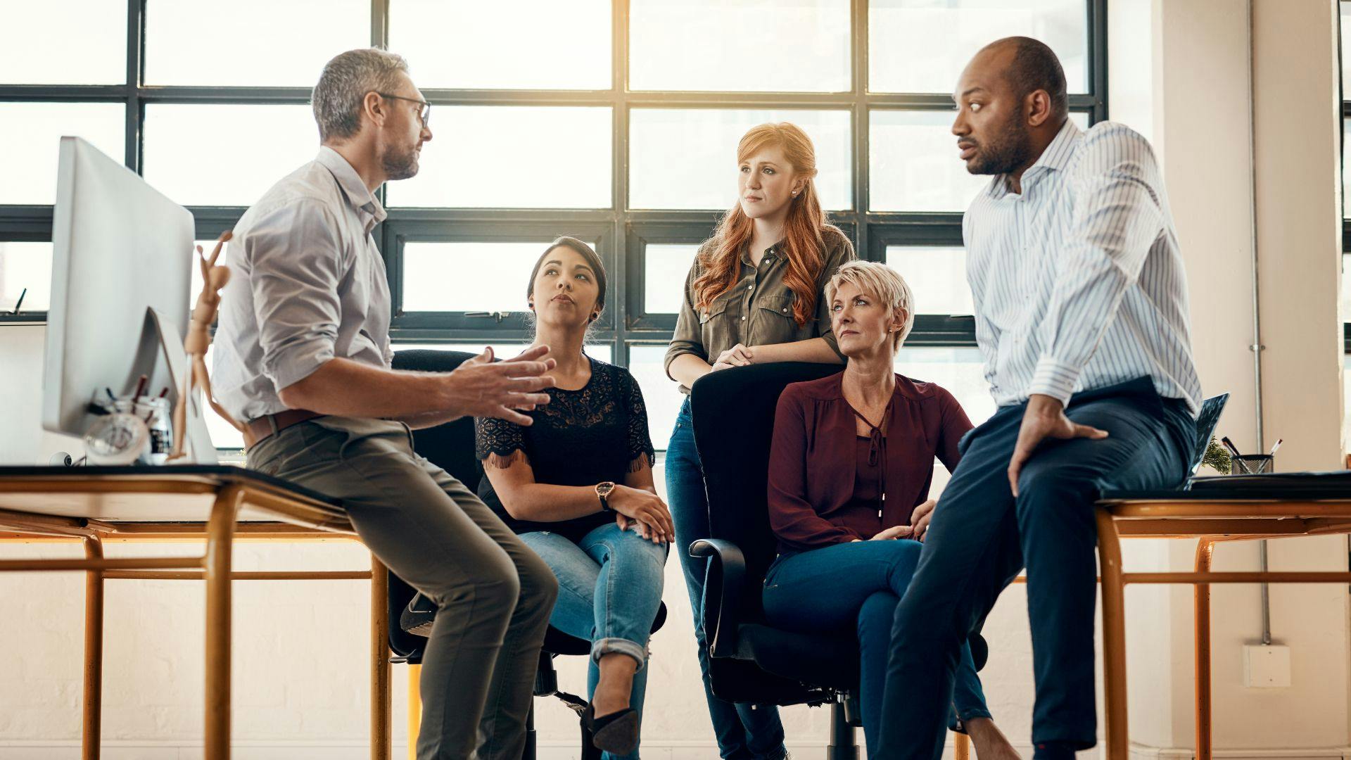 A group of professionals having a discussion in a modern office setting.